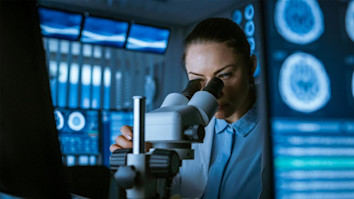 Medical Research Scientist Looking Through the Microscope