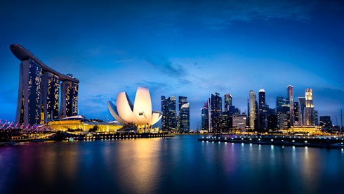 Twilight at Marina Bay in Singapore, where numerous skyscrapers are lit up over the water