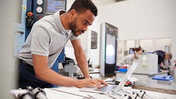 Engineer using CAD programming software on laptop