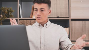 A student looking confused at a laptop 