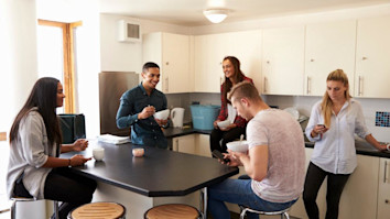 students relaxing in kitchen of shared accommodation
