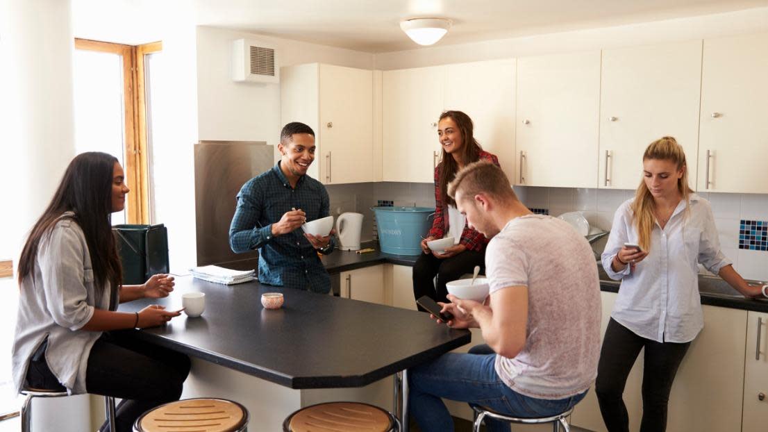 students relaxing in kitchen of shared accommodation