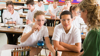 Young science students listening to teacher