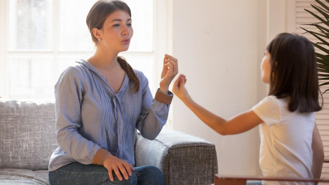 speech therapist doing exercise, speaking with little girl patient