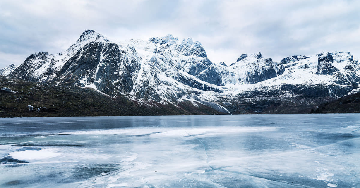 snowy mountains overlooking a frozen lake