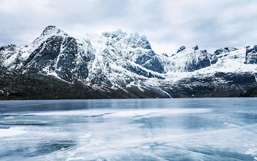 snowy mountains overlooking a frozen lake