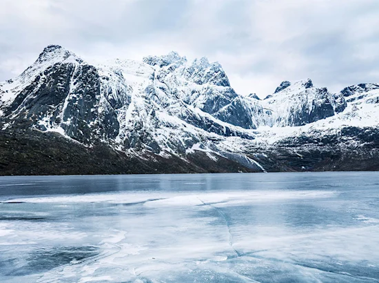 snowy mountains overlooking a frozen lake