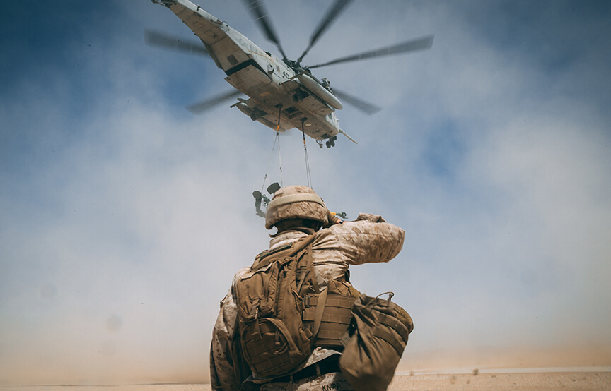 military personal below a helicopter 