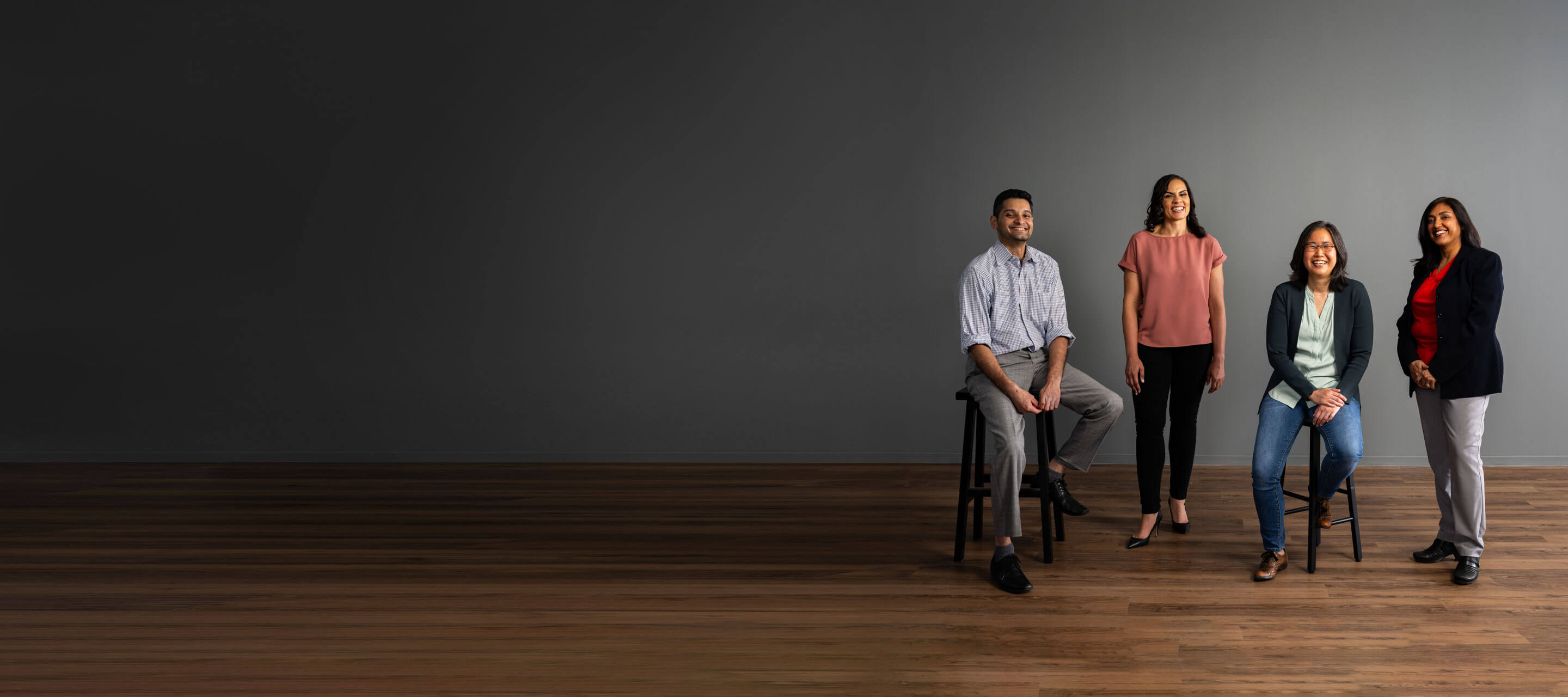 colleagues standing together by a grey wall