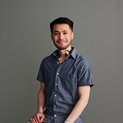 Zachary Monte posing by grey wall