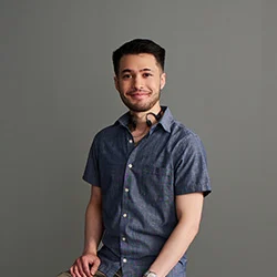 Zachary Monte posing by grey wall