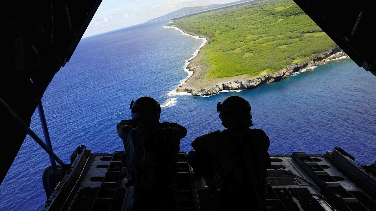 two soldiers sitting in the back of the plane