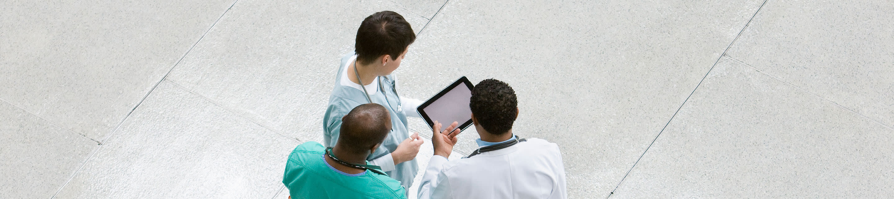group of doctors talking around a tablet