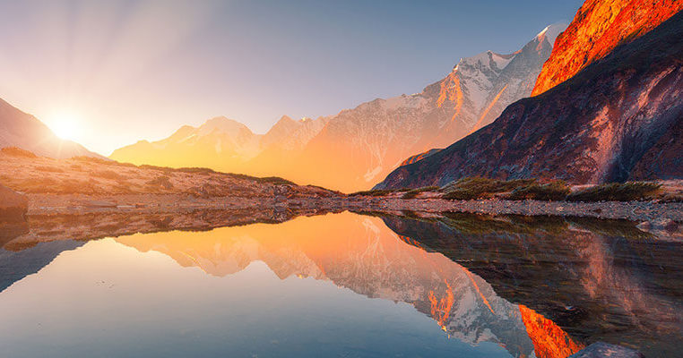 Lake with a sun reflection and mountains