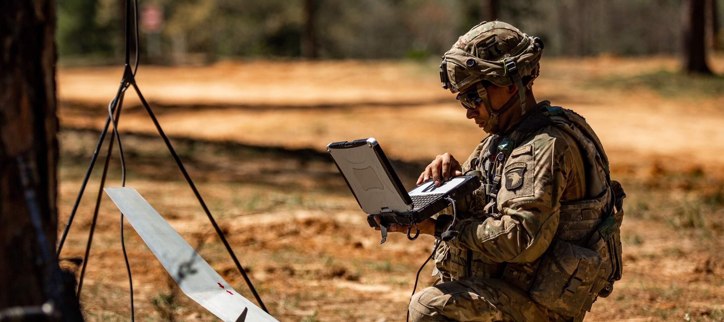 solider working on a laptop in the field