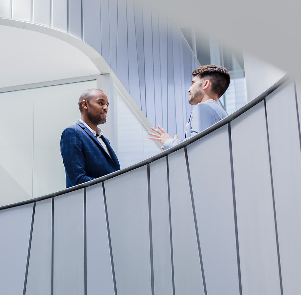 two men talking on a staircase