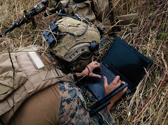 soldier on the ground looking at computer