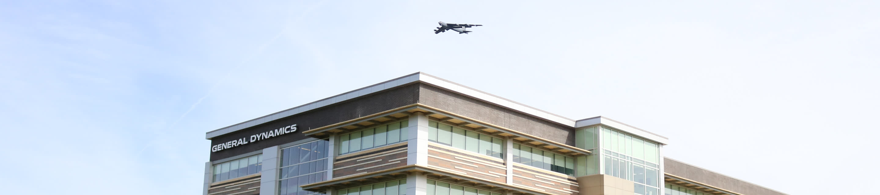 Military plane flying over GDIT building