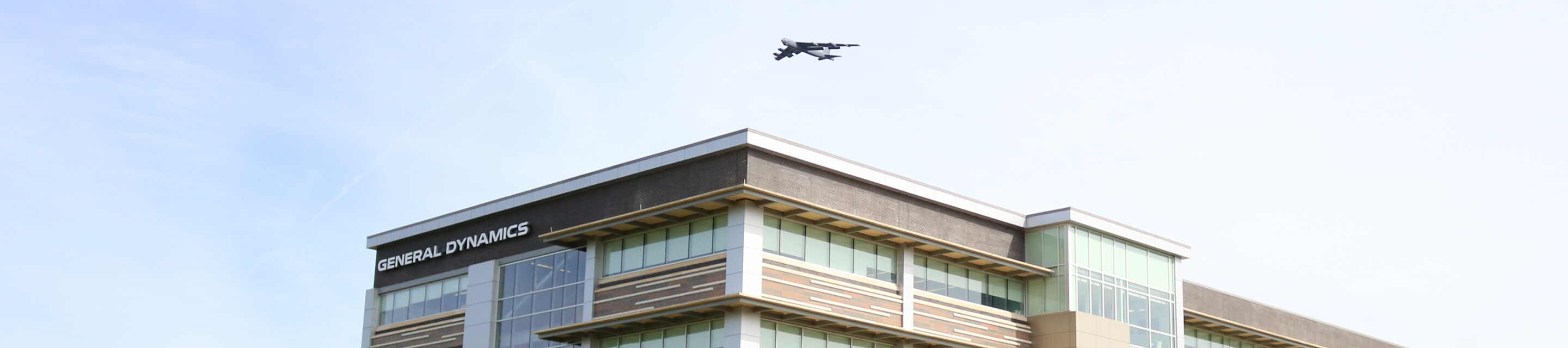 Military plane flying over GDIT building