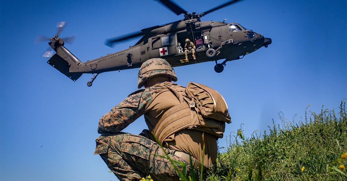 soldier looking up at a medical helicopter