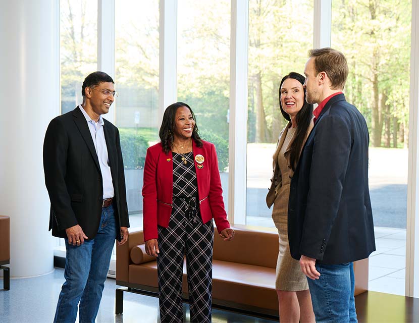 coworkers standing together talking in a lobby 
