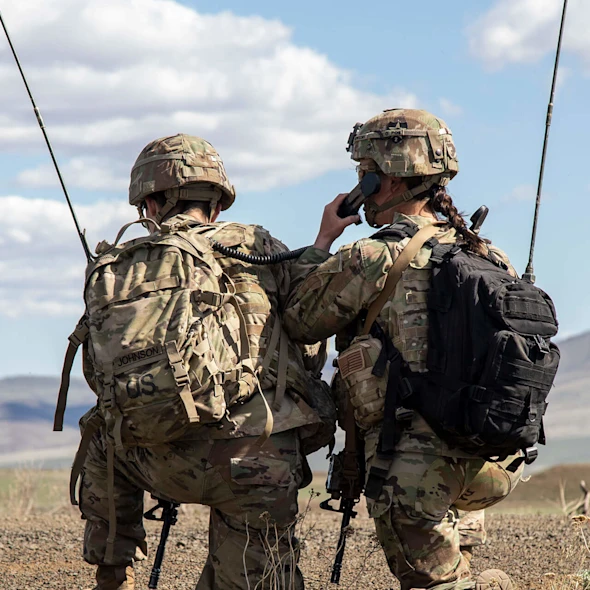 two soldiers kneeling in the field together