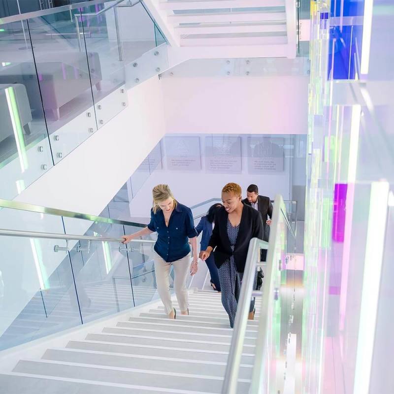 image shows coworkers walking up the stairs together while talking