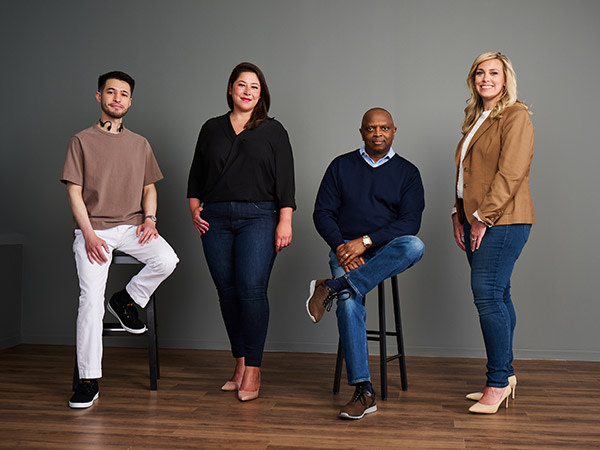 group of diverse employees by a grey wall