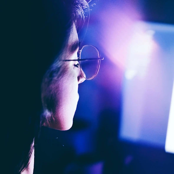 young woman working late on computer in a dimly lit room
