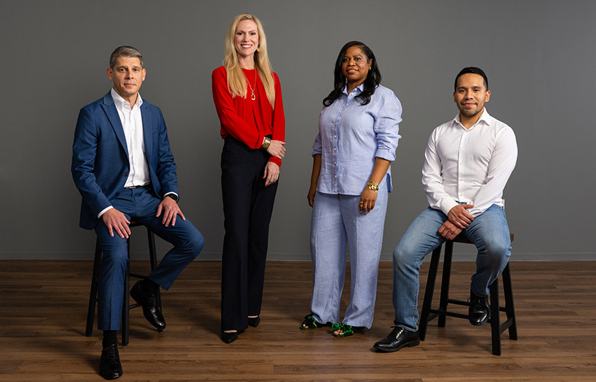 group of employees standing together by grey wall