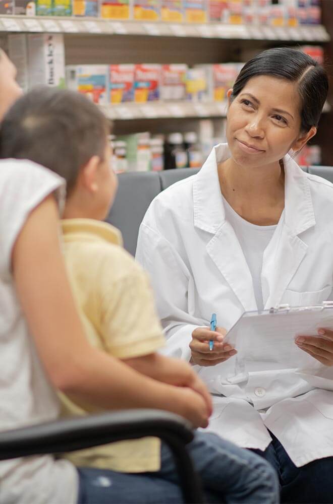 doctor talking to mother who is holding small child boy in lap