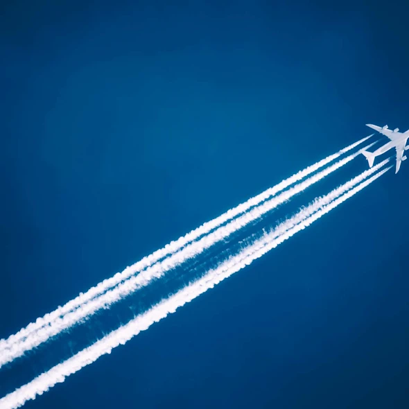 image shows plane with trail flying