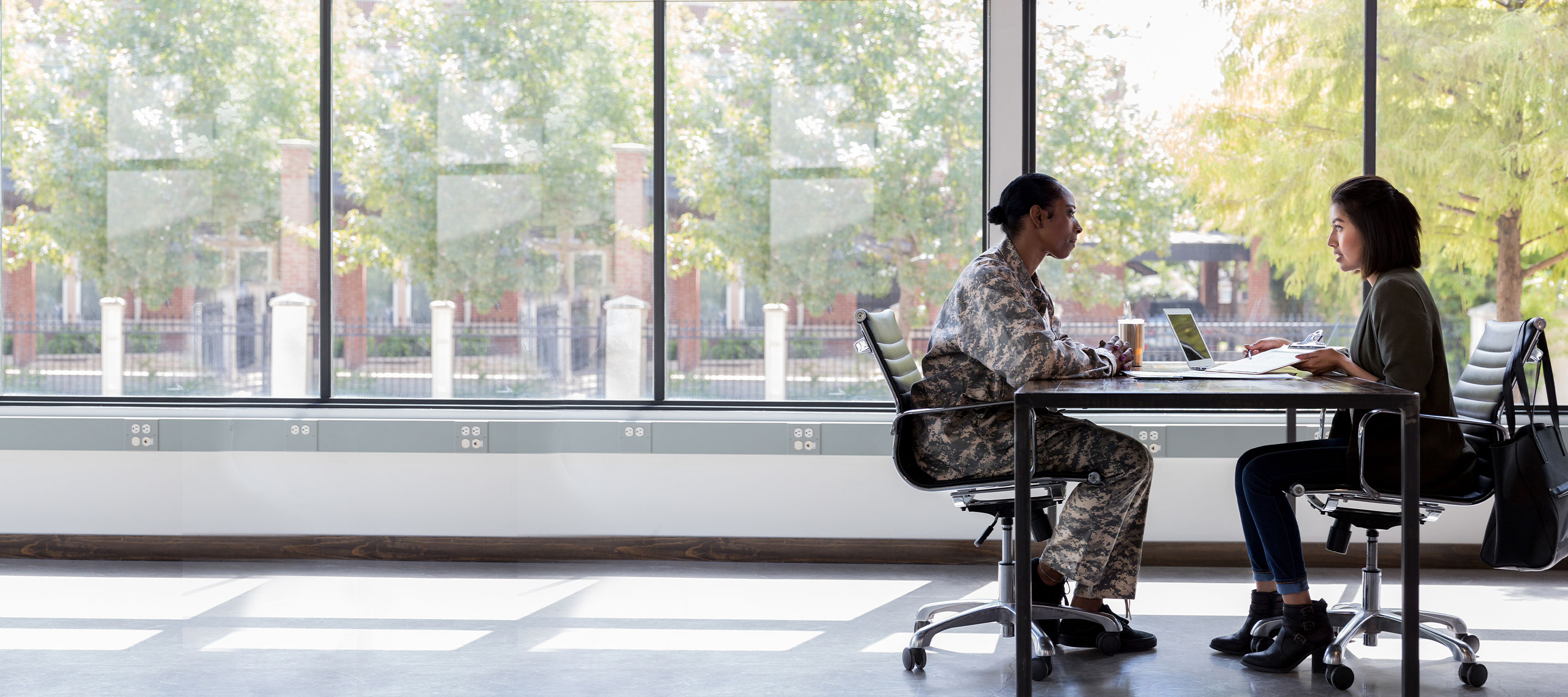 a veteran and a professional seated at a desk talking