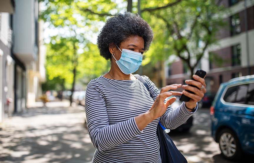 woman wearing a mask and looking at phone