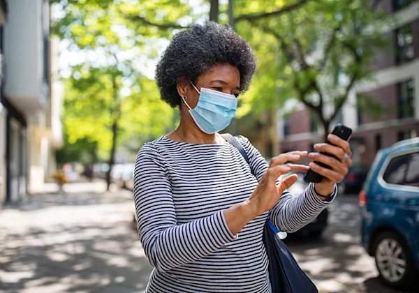 woman wearing a mask and looking at phone