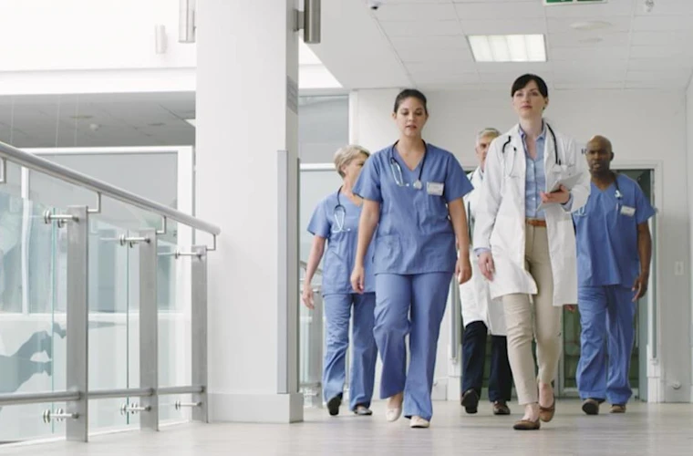 nurses and doctors walking through hospital halls
