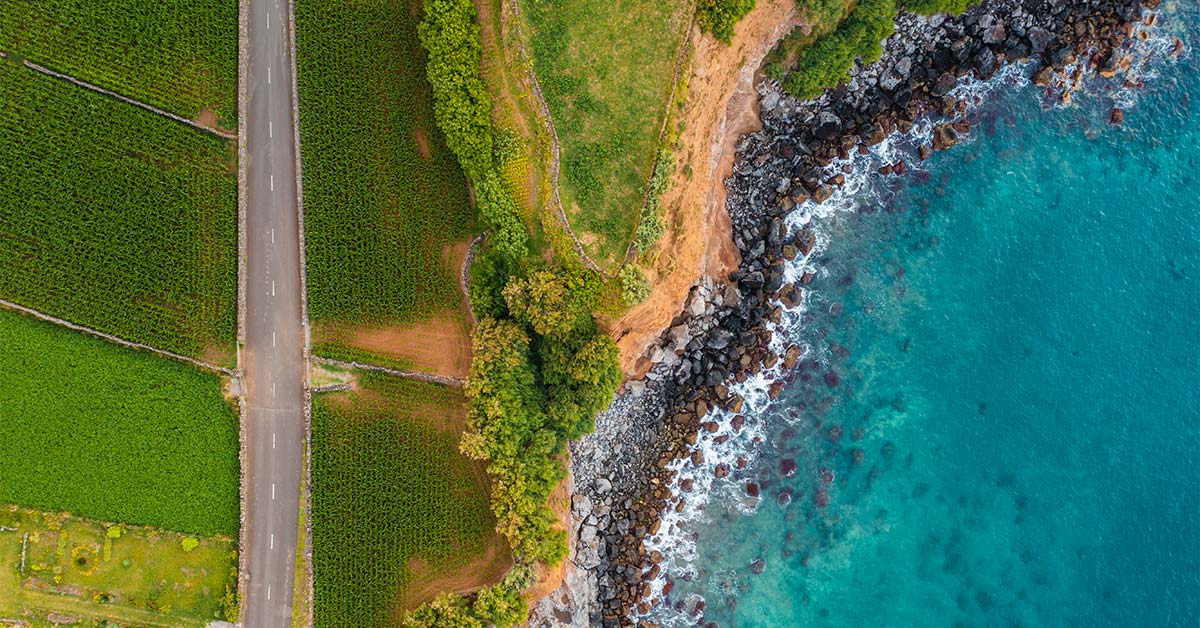 image shows road on land split with sea