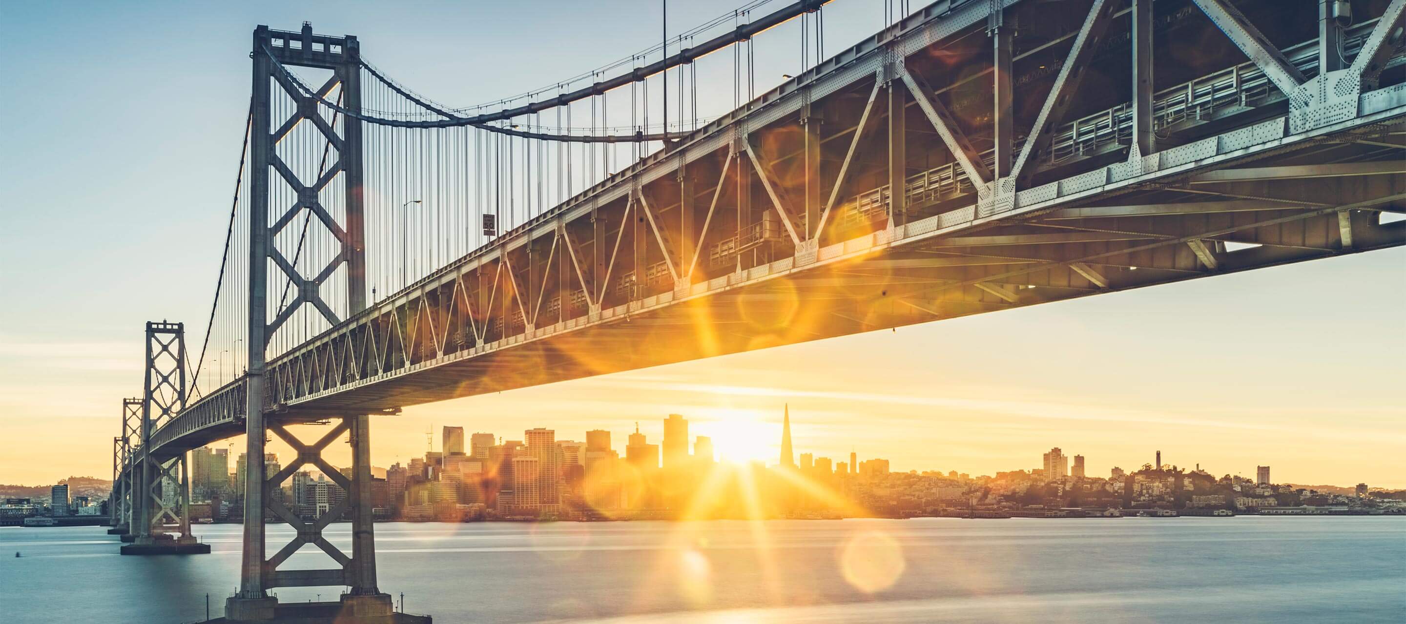 image of a bridge over water at sunset