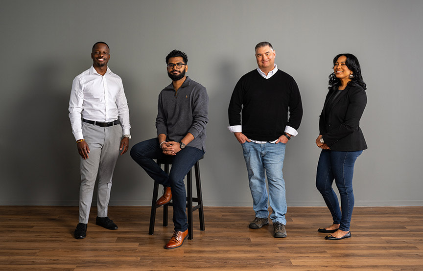 GDIT employees standing by a grey wall