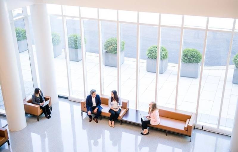 image shows coworkers sitting in a lobby