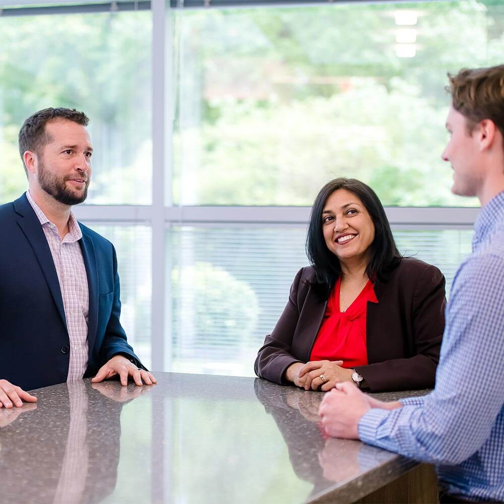 coworkers talking to one another around a countertop