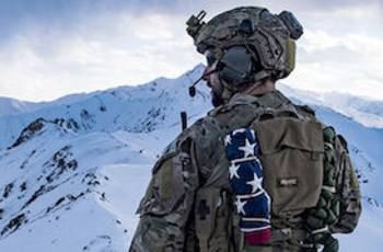 Solider standing in snow covered mountains 