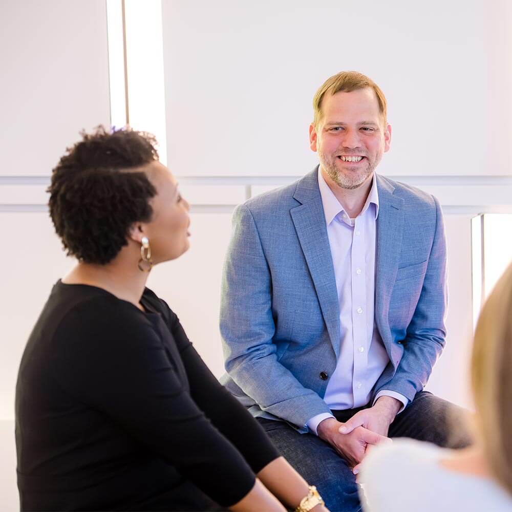 a man and woman sitting on a bench talking in the office