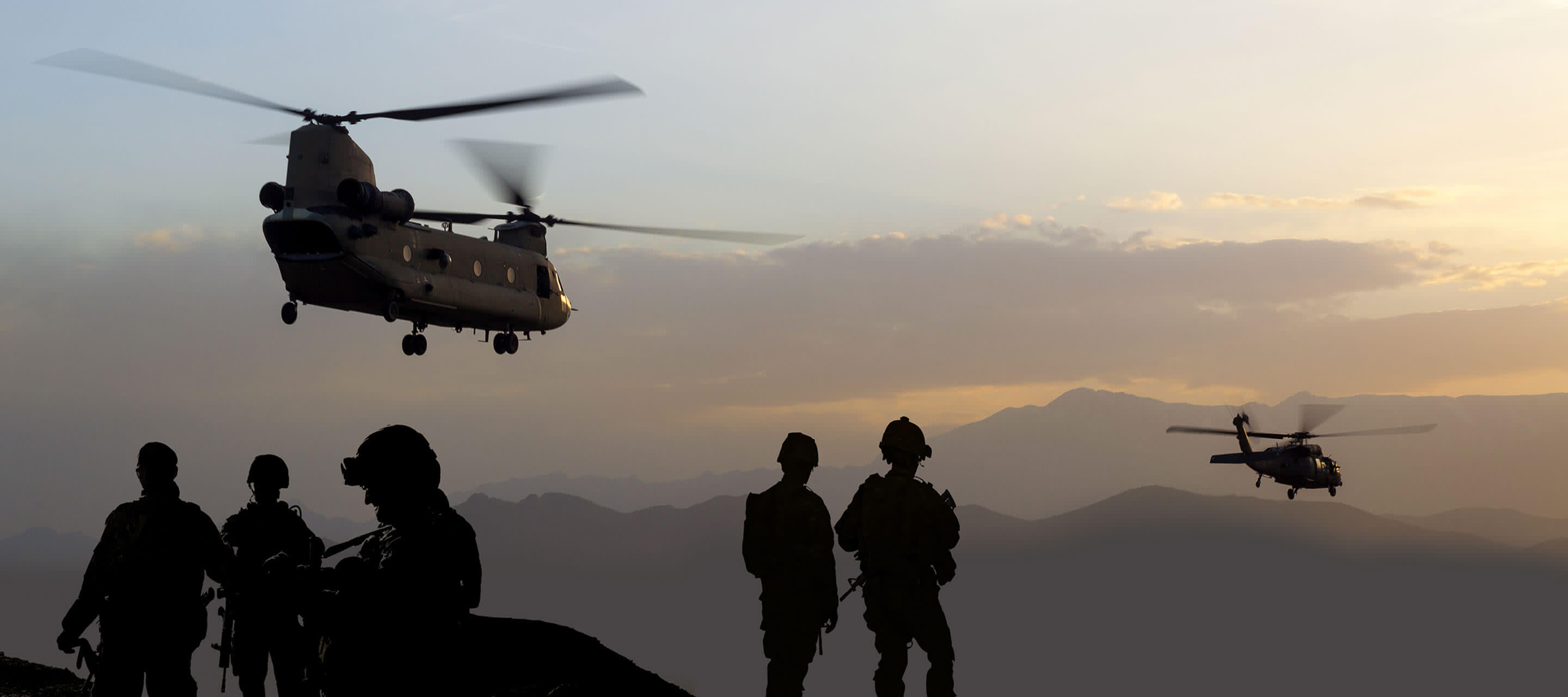 Shadows of soldiers and helicopters in mountains.