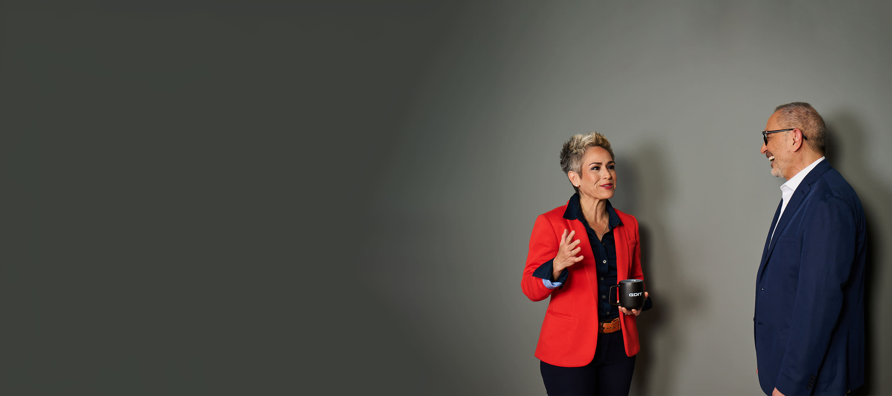 female and male colleague talking, grey background