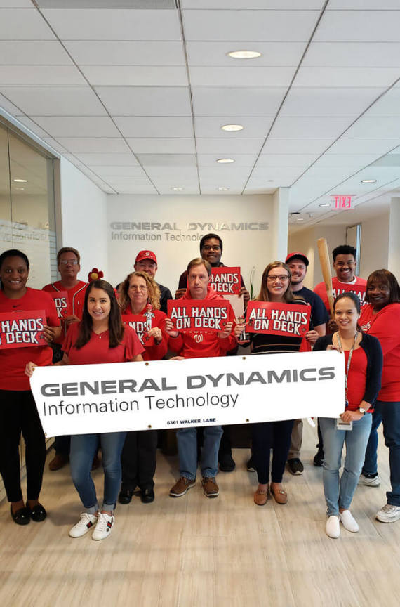GDIT employees showing support for the Washington Nationals in the office with shirts and signs