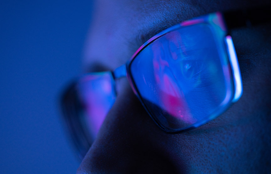 zoom-in shot of man wearing glasses with light reflecting