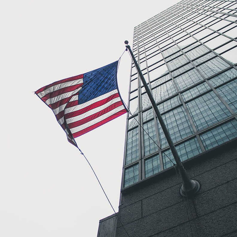 american flag on a tall city building