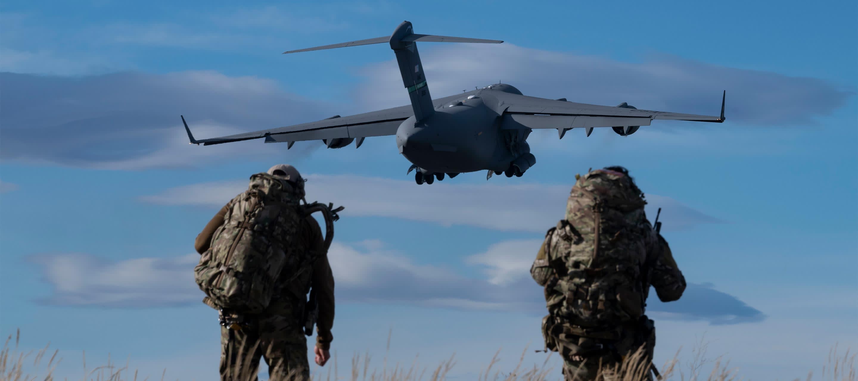 image shows two soldiers moving towards a plane overhead
