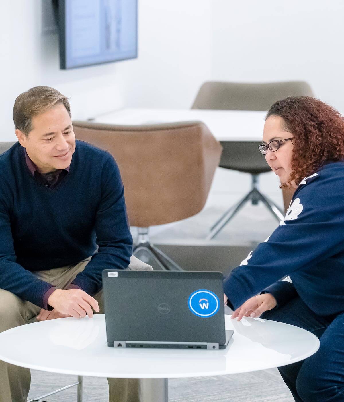 two coworkers talking at a table